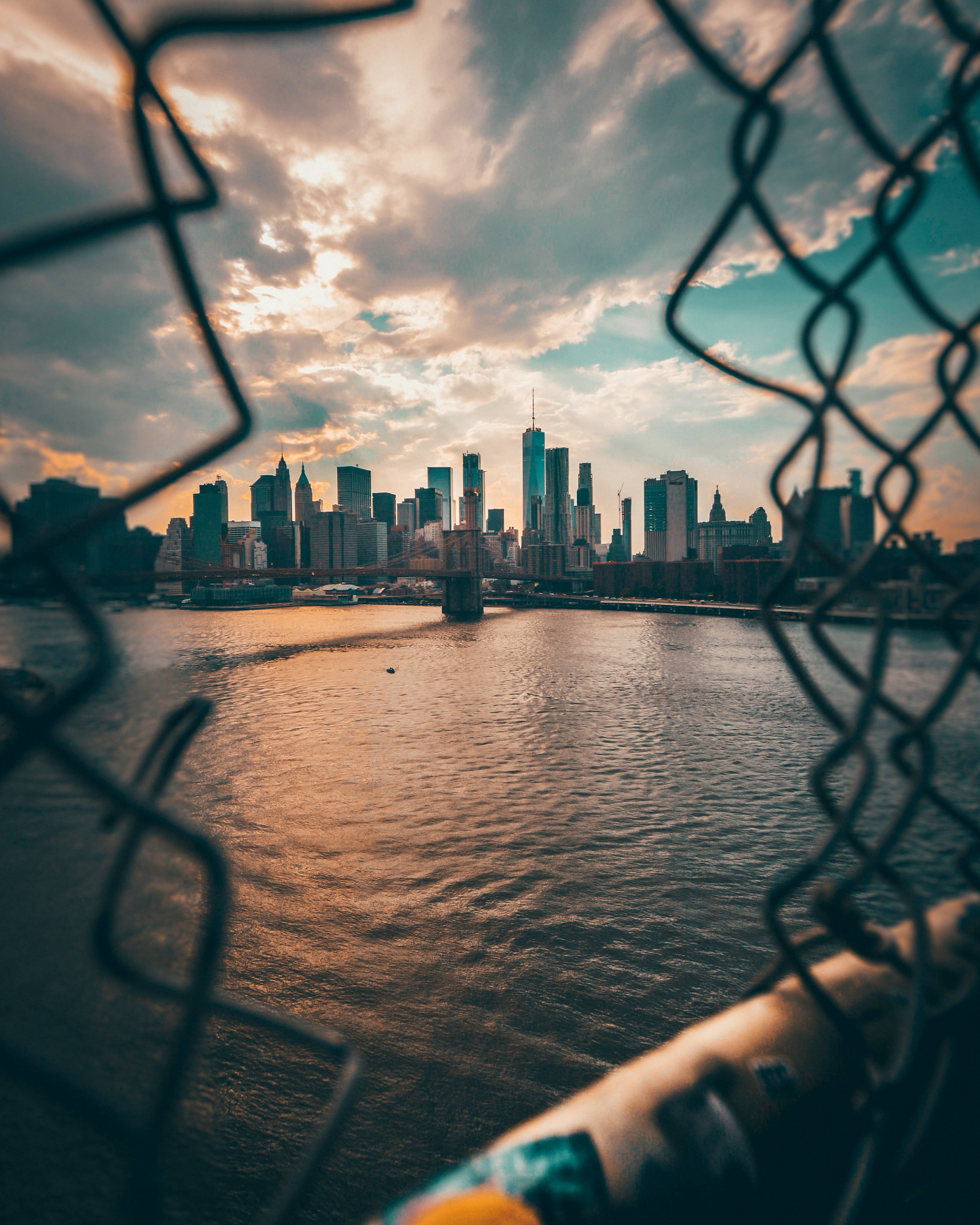 gray fence overlooking body of water far at the city